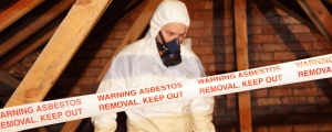 Asbestos Remediation - A specially trained worker wears protective clothing while clearing the asbestos. 